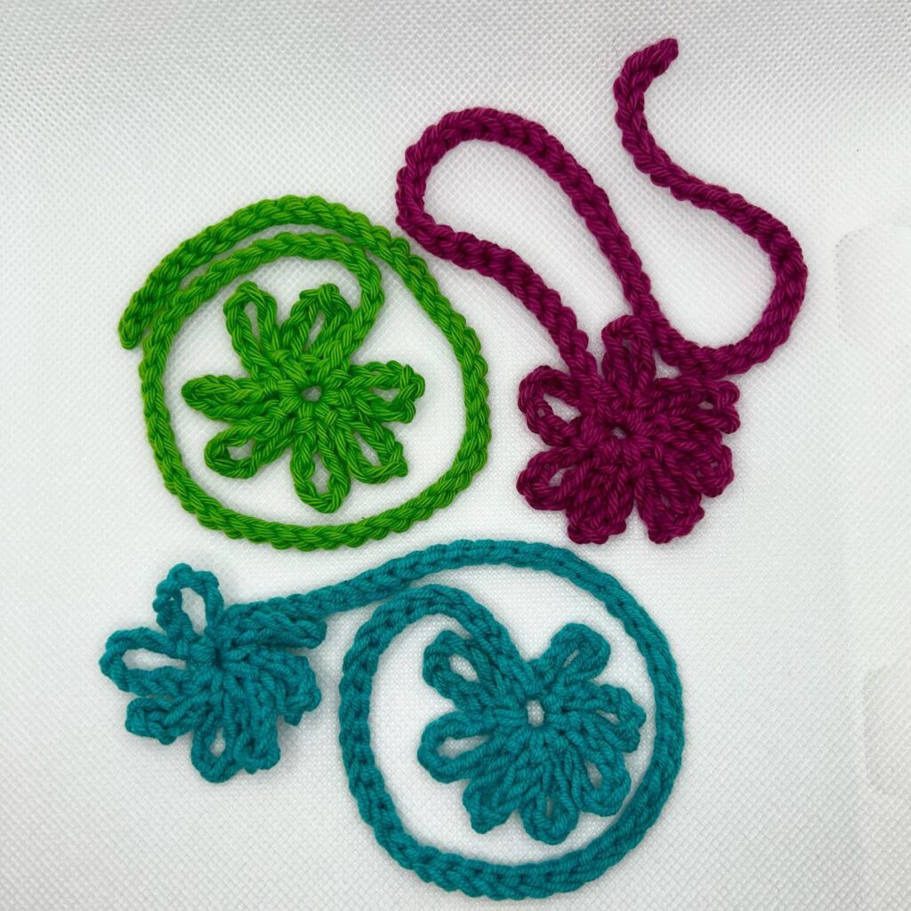 Examples of different colours of the crochet simple daisy bookmark